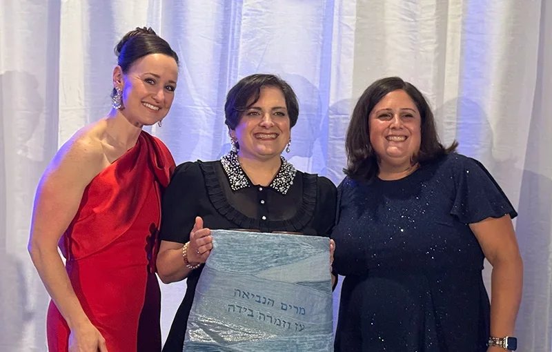 three women posing at gala